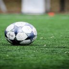 soccer ball - GC Network Solutions Soccer ball resting on a green turf field with blurred background.